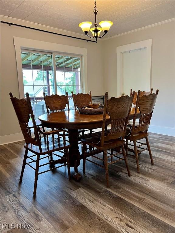 dining room with crown molding, a healthy amount of sunlight, and dark wood-style floors