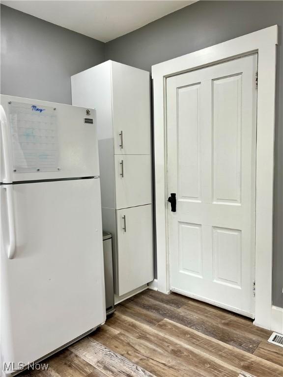 kitchen with visible vents, freestanding refrigerator, and wood finished floors