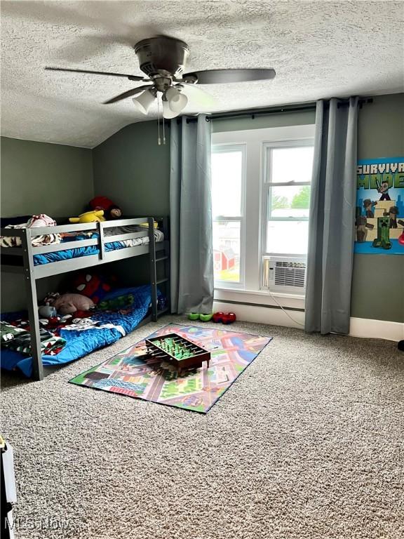 bedroom with carpet floors, a textured ceiling, cooling unit, a ceiling fan, and vaulted ceiling