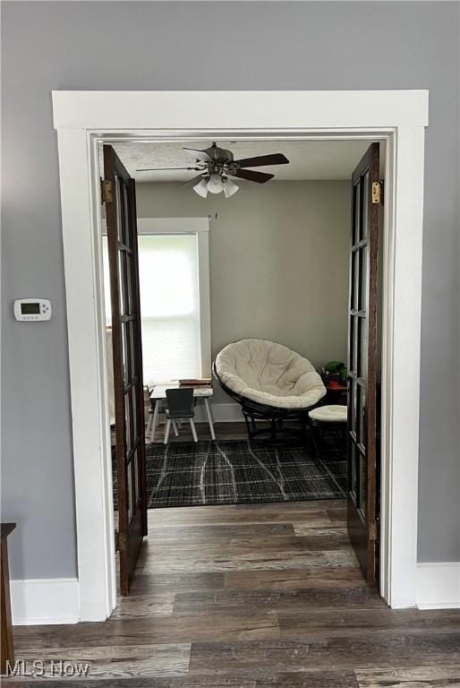 corridor with baseboards and dark wood-style floors