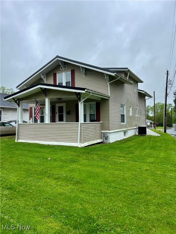 view of side of property with a lawn, central AC unit, and a porch