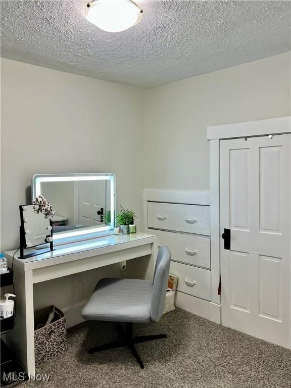 carpeted office with a textured ceiling