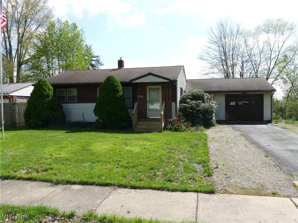 view of front of home featuring fence, an attached garage, aphalt driveway, a front yard, and a chimney