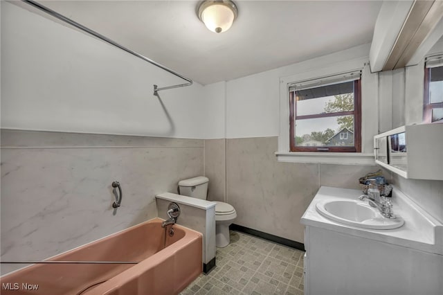 full bathroom with toilet, baseboards, a garden tub, vanity, and tile patterned floors