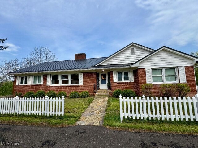 ranch-style home featuring fence, a chimney, a front lawn, and brick siding