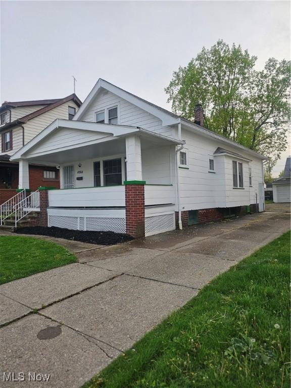 view of home's exterior featuring covered porch and a chimney