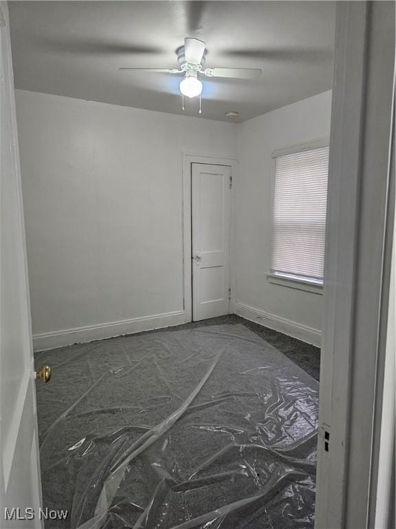 spare room featuring baseboards and a ceiling fan