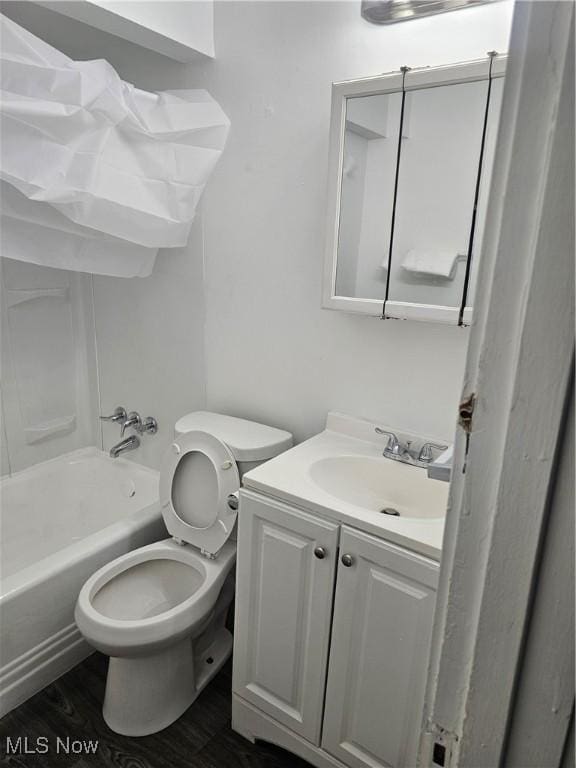 bathroom with toilet, shower / bath combination, wood finished floors, and vanity