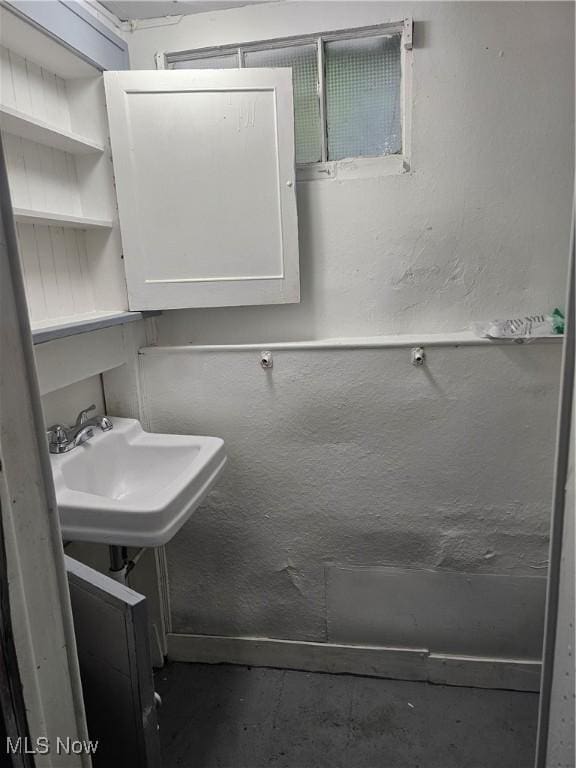 bathroom with a sink and unfinished concrete floors