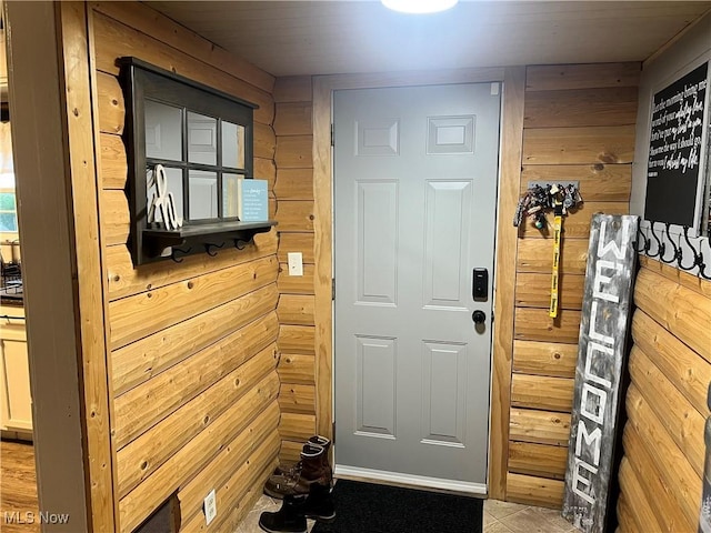 doorway to outside with wooden walls