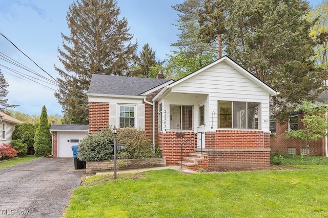 23267 Marion Rd, North Olmsted, OH 44070 - bungalow featuring an outdoor structure, a chimney, a front lawn, and brick siding