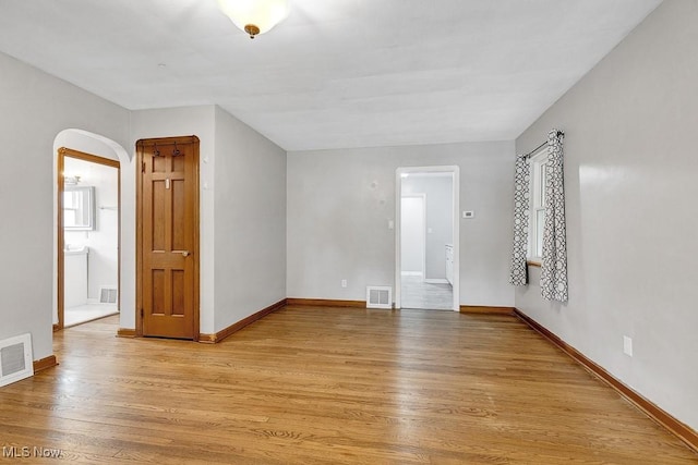 23267 Marion Rd, North Olmsted, OH 44070 - spare room with visible vents, arched walkways, and light wood-type flooring