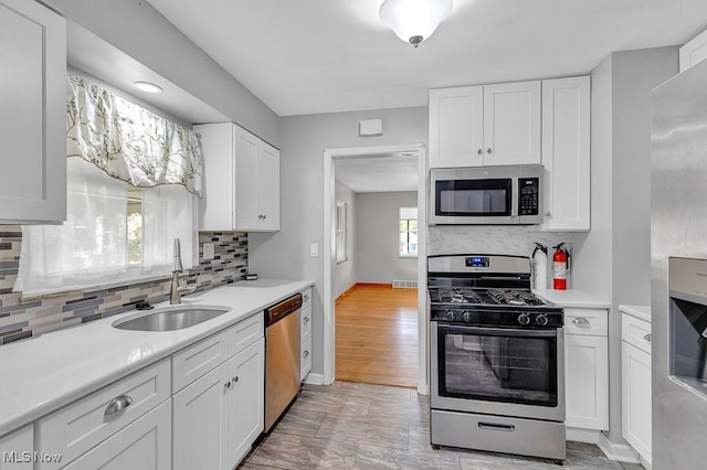 23267 Marion Rd, North Olmsted, OH 44070 - kitchen with light countertops, stainless steel appliances, white cabinets, and a sink