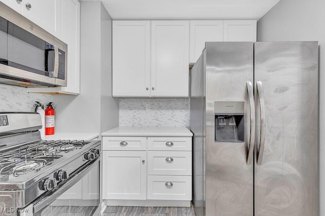 23267 Marion Rd, North Olmsted, OH 44070 - kitchen with light countertops, white cabinets, appliances with stainless steel finishes, and tasteful backsplash