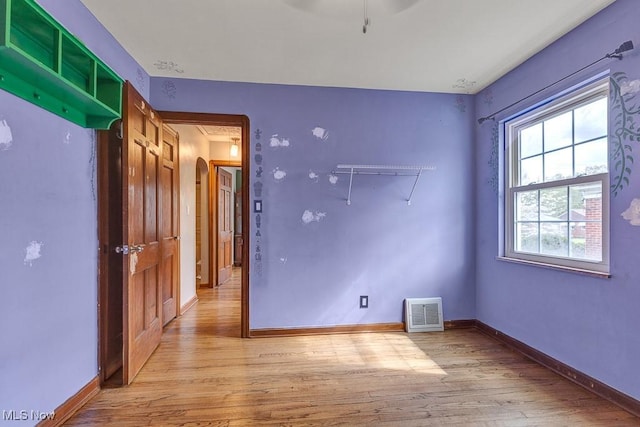 23267 Marion Rd, North Olmsted, OH 44070 - spare room featuring arched walkways, baseboards, visible vents, and light wood-style floors