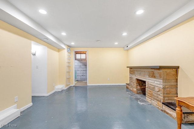 23267 Marion Rd, North Olmsted, OH 44070 - unfurnished living room featuring finished concrete floors, recessed lighting, baseboards, and a stone fireplace