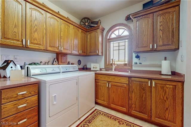 laundry room featuring a sink, cabinet space, light tile patterned floors, and washer and dryer