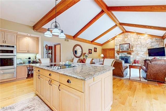 kitchen featuring light wood-style flooring, a warming drawer, black electric stovetop, and light brown cabinetry