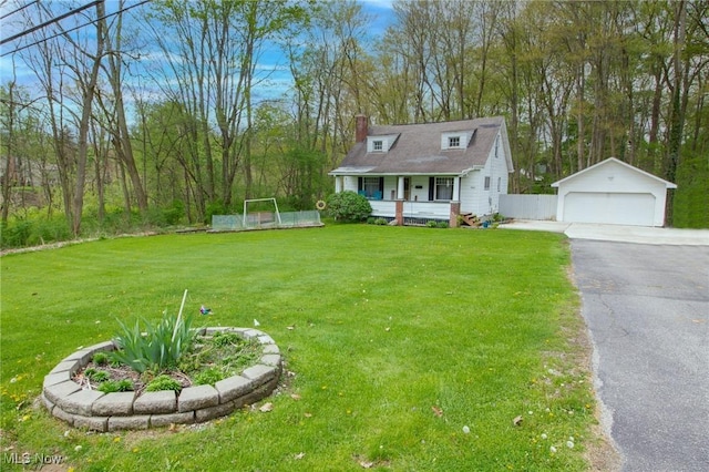 view of front of property featuring a garage, a front lawn, a chimney, a porch, and an outbuilding