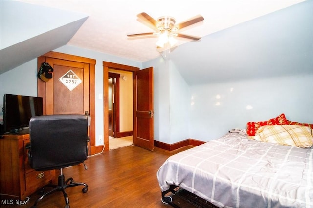 bedroom featuring baseboards, ceiling fan, vaulted ceiling, and wood finished floors