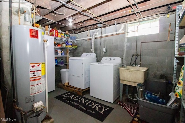 washroom featuring laundry area, a sink, water heater, and washing machine and dryer
