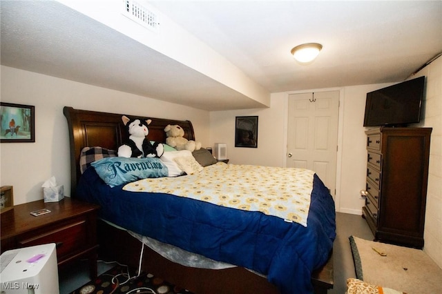 bedroom with visible vents and dark carpet