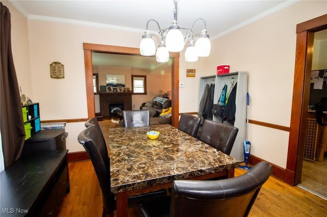 dining space featuring baseboards, ornamental molding, and wood finished floors