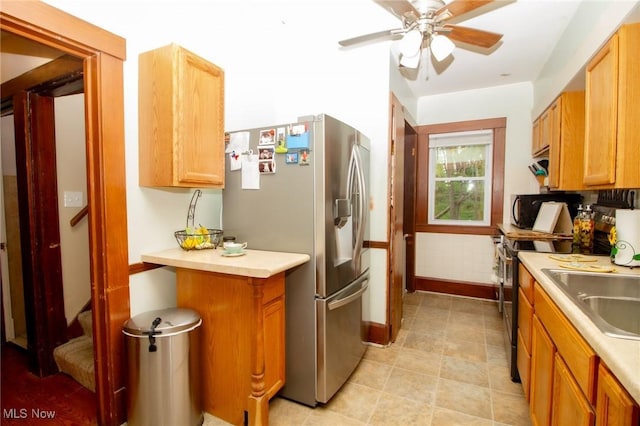 kitchen featuring light countertops, baseboards, ceiling fan, and stainless steel appliances