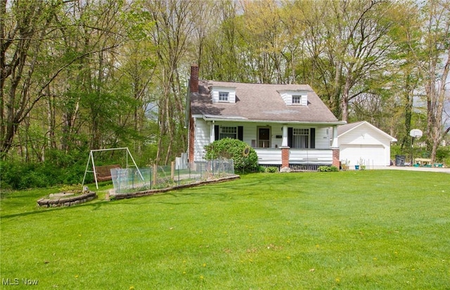 view of front of house featuring a front lawn, an outbuilding, a chimney, and a detached garage