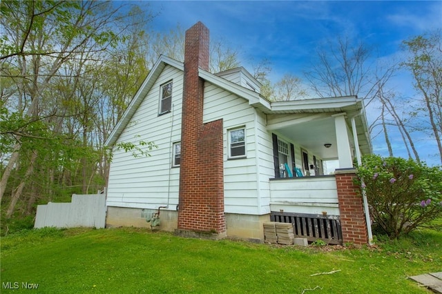 view of home's exterior with a yard and a chimney