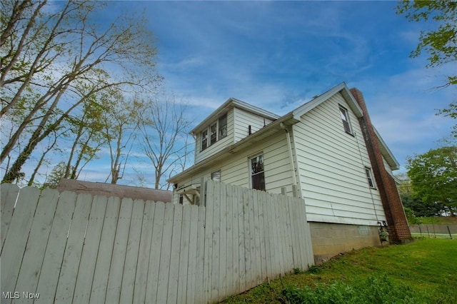 view of home's exterior featuring fence and a chimney