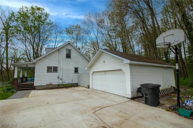 view of side of home featuring a detached garage, an outdoor structure, and a porch