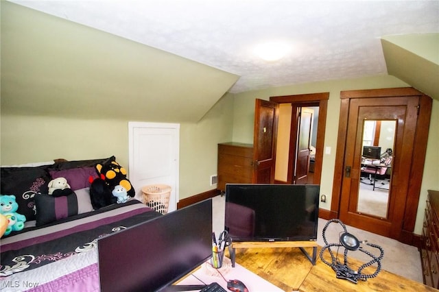 bedroom with visible vents, baseboards, and lofted ceiling
