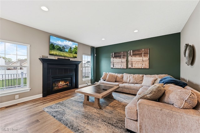 living room featuring visible vents, wood finished floors, a fireplace, baseboards, and recessed lighting