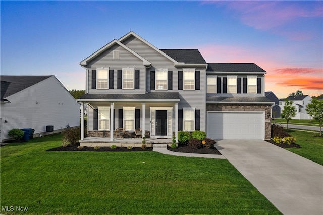 traditional-style home with a garage, covered porch, driveway, and stone siding
