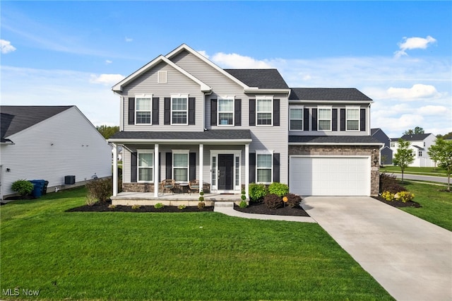 view of front of home with a porch, a front lawn, concrete driveway, an attached garage, and stone siding