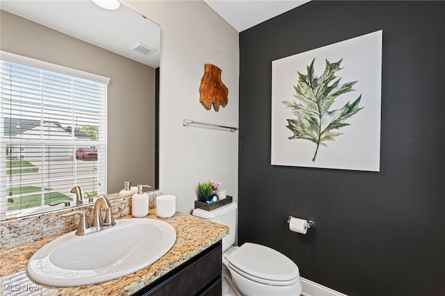 bathroom with visible vents, toilet, and vanity