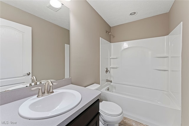 bathroom featuring toilet, a textured ceiling, tub / shower combination, and vanity