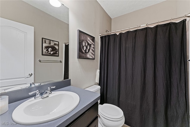 bathroom with vanity, a shower with curtain, toilet, and a textured ceiling