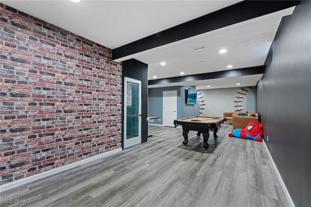 game room featuring beam ceiling, wood finished floors, brick wall, baseboards, and pool table