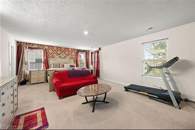 bedroom with a textured ceiling, visible vents, light carpet, and baseboards