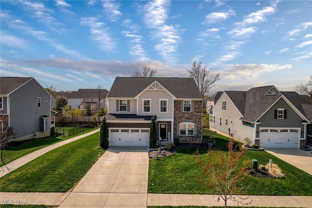 traditional home with an attached garage, driveway, stone siding, and a front yard