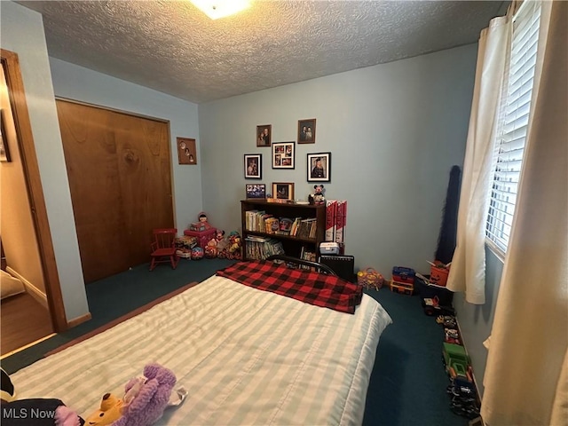 bedroom featuring a textured ceiling and carpet
