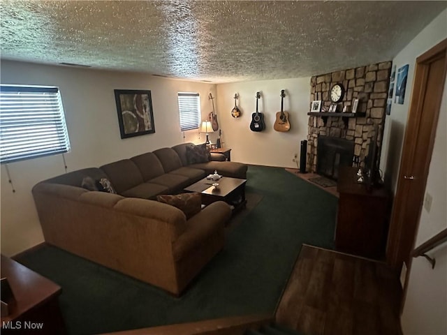 living area featuring a stone fireplace, a textured ceiling, and visible vents