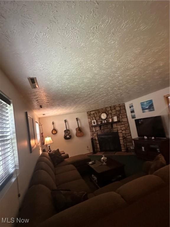 living room with a fireplace and a textured ceiling