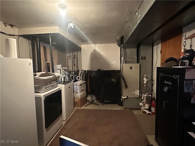 basement featuring carpet floors, freestanding refrigerator, and washing machine and clothes dryer