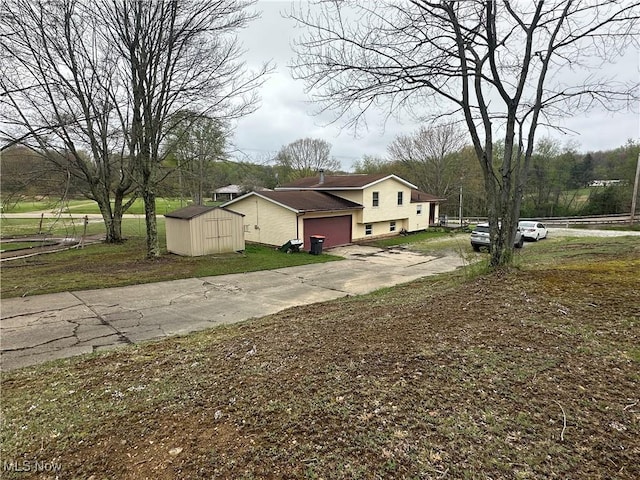 view of side of home featuring an attached garage, an outbuilding, a shed, and driveway