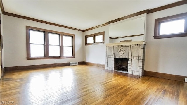3996 Bluestone Rd, Cleveland Heights, OH 44121 - unfurnished living room featuring visible vents, ornamental molding, a brick fireplace, hardwood / wood-style floors, and baseboards