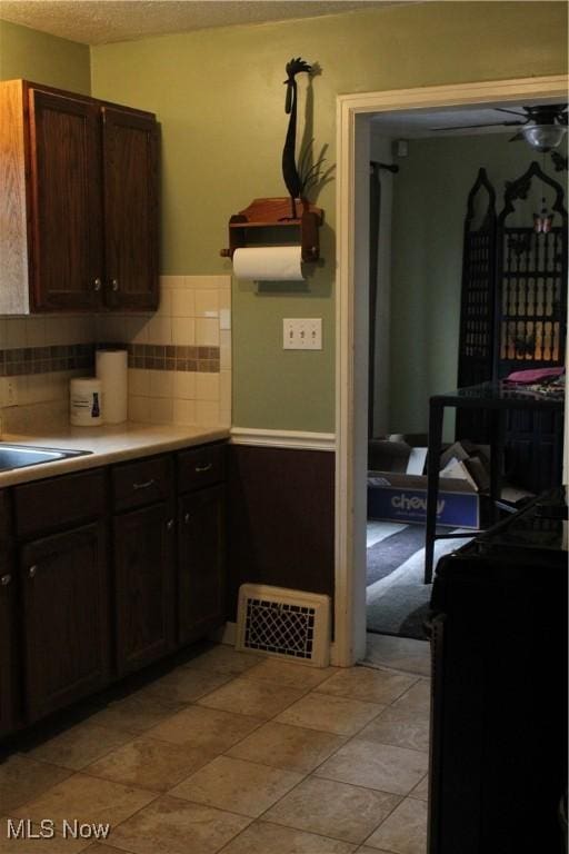864 Davies Ave, Akron, OH 44306 - kitchen featuring ceiling fan, a sink, light countertops, decorative backsplash, and visible vents