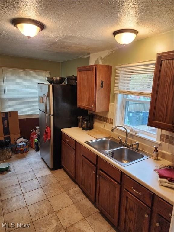 864 Davies Ave, Akron, OH 44306 - kitchen featuring a sink, a textured ceiling, decorative backsplash, and light countertops